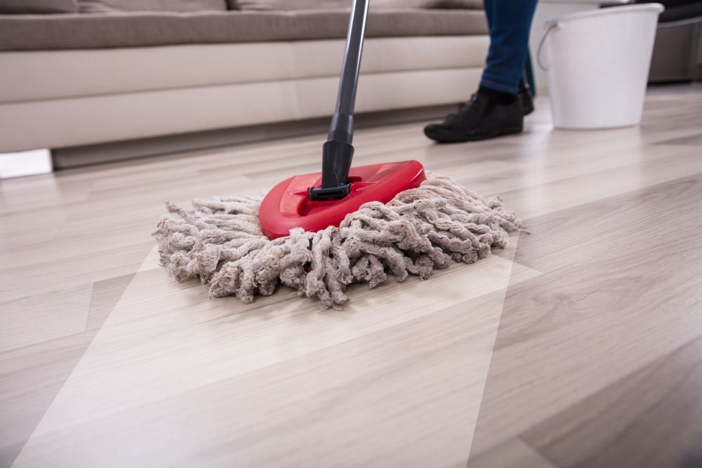 Person Mopping a Light-colored Wood Floor — DAH Cleaning Services In Atherton, QLD