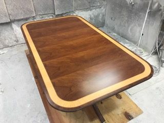 Wooden coffee table with a dark brown center and a light brown border.