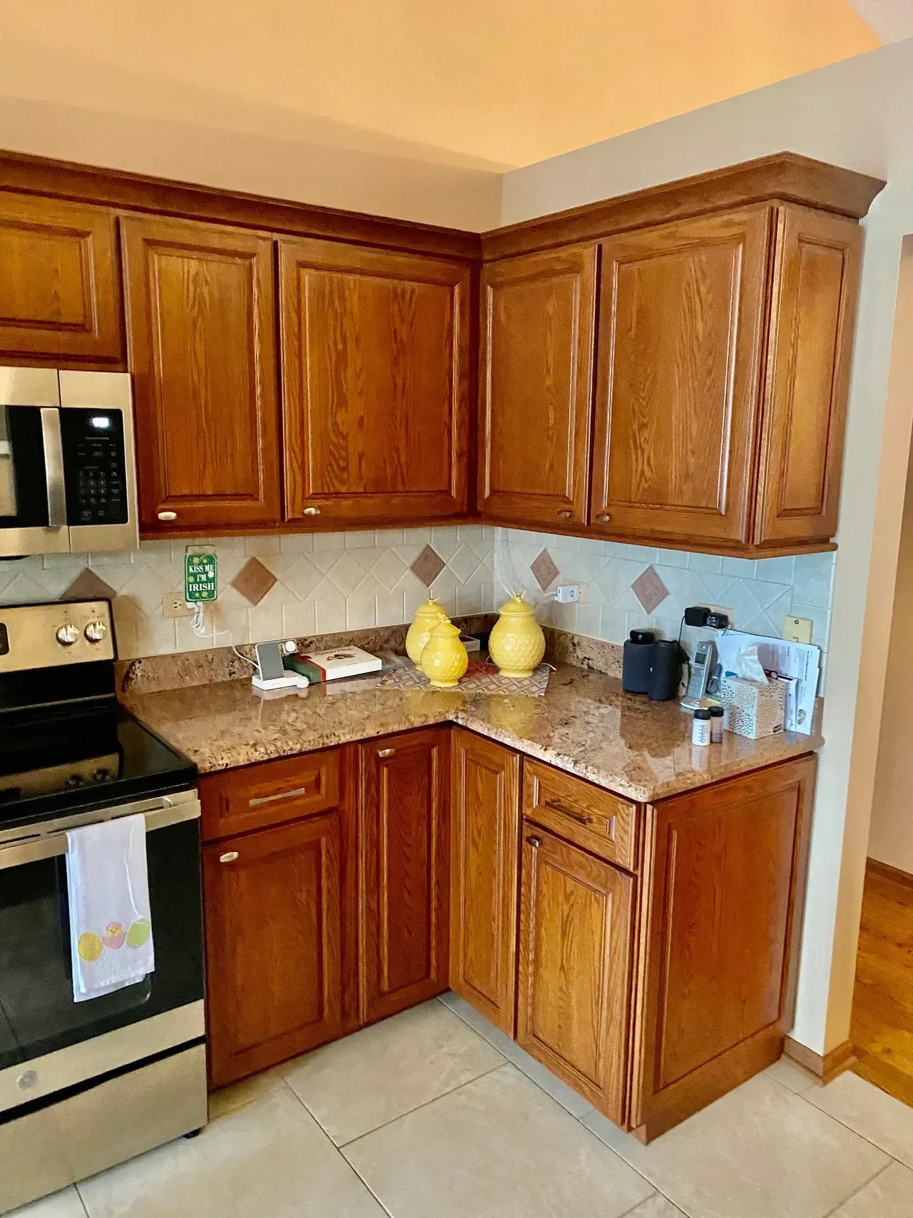Corner kitchen with wooden cabinets, granite countertops, and tile backsplash.
