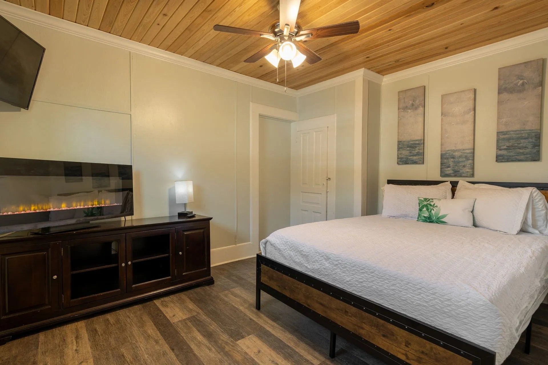 A quiet, warm guest room at Depot Village with a made bed and wood ceiling