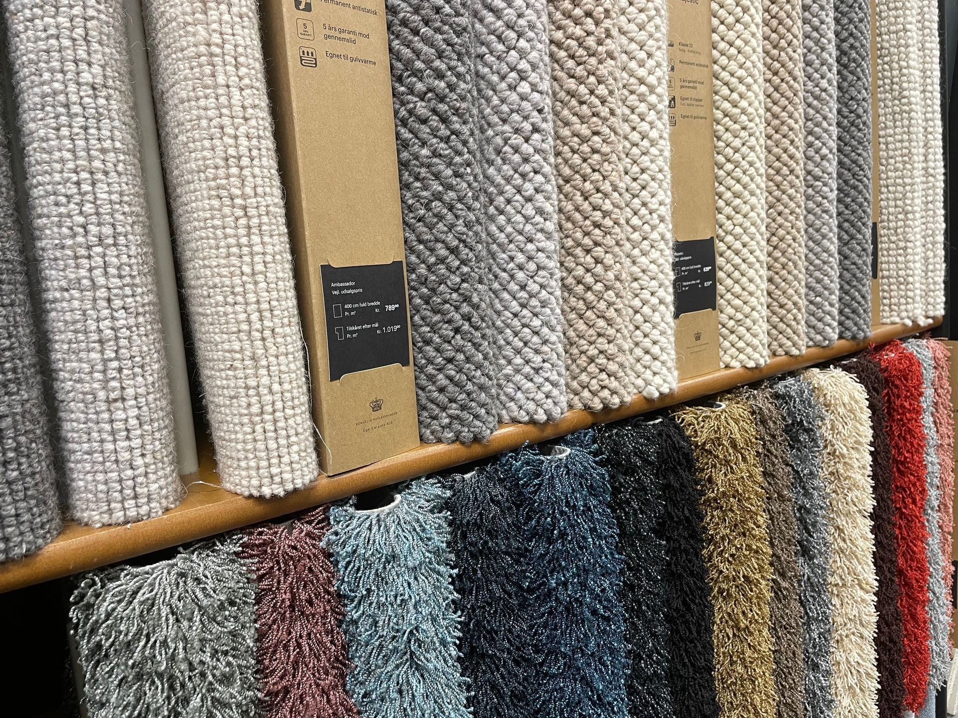 Et nærbillede af et sort og hvidt tæppe og puder på en seng.