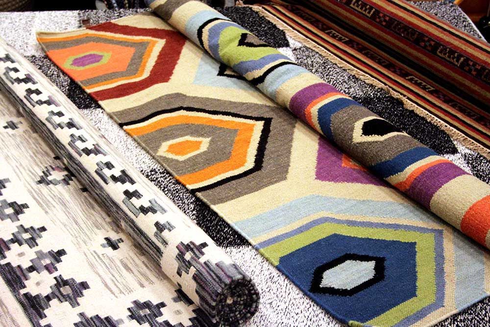 En flok farverige tæpper er stablet oven på hinanden