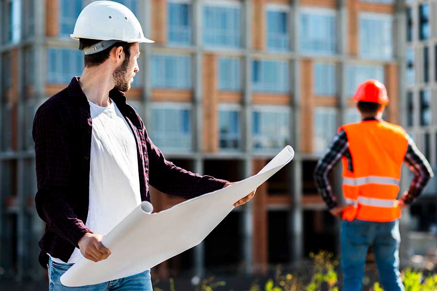 a man in a hard hat looking at a blueprint