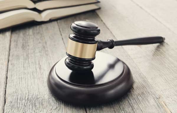 a judge 's gavel is sitting on a wooden table next to a book .