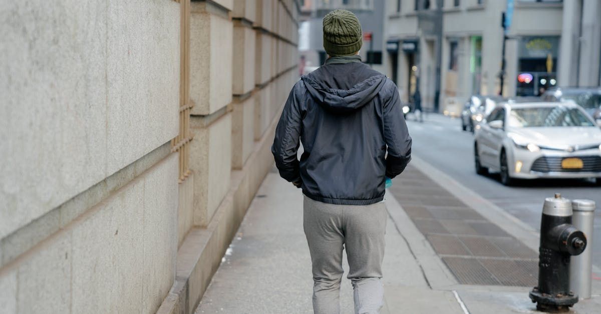 A man is walking down a sidewalk on a city street.