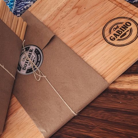 Tablas de picar y etiquetas estampadas sobre una superficie de madera.