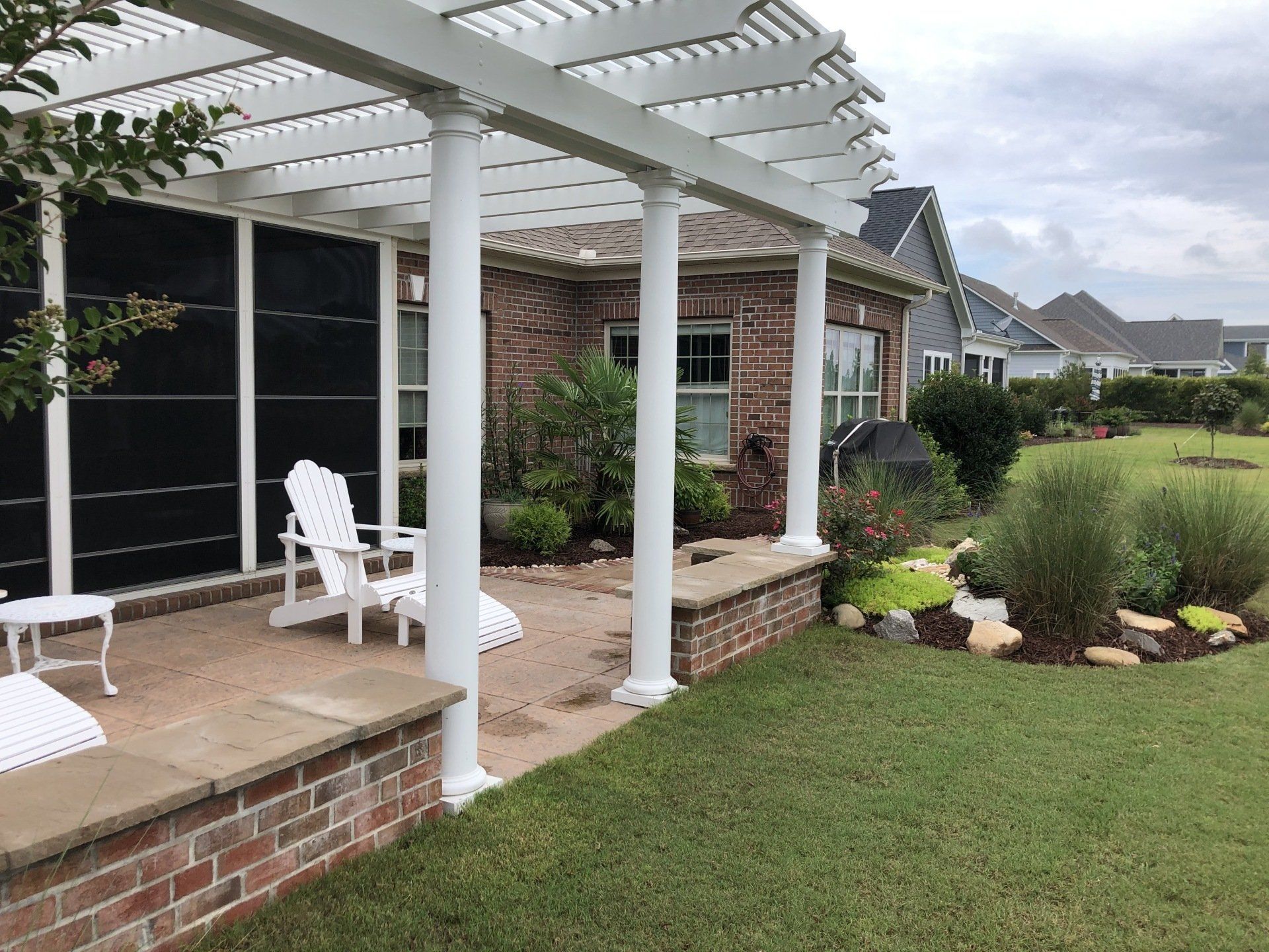 Pergola installation with white pillars and a patio