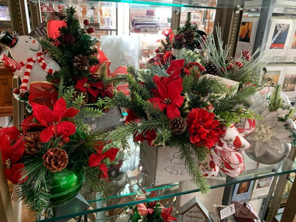 A display case filled with christmas decorations and flowers.
