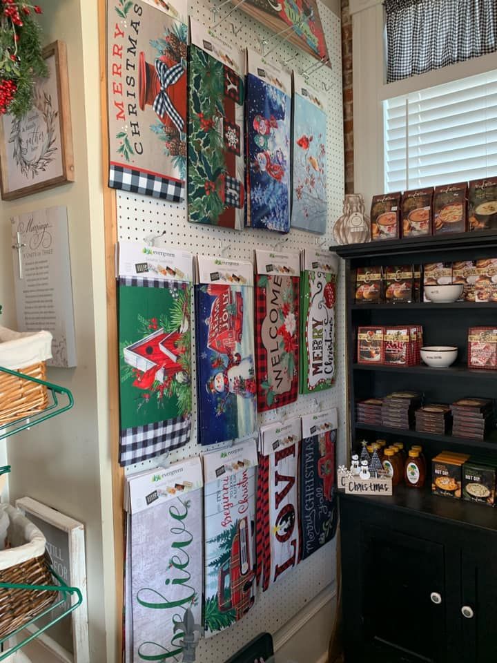 A bunch of christmas signs are hanging on a wall in a store.