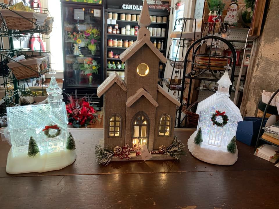 Two christmas decorations are sitting on a table in a store.