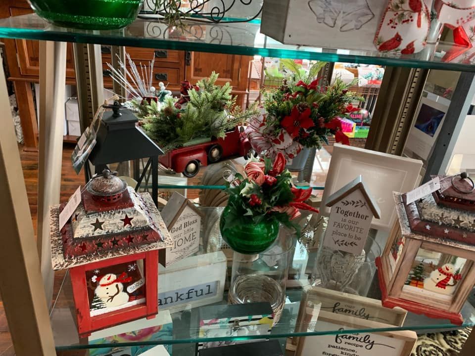 A glass shelf filled with lots of christmas decorations.