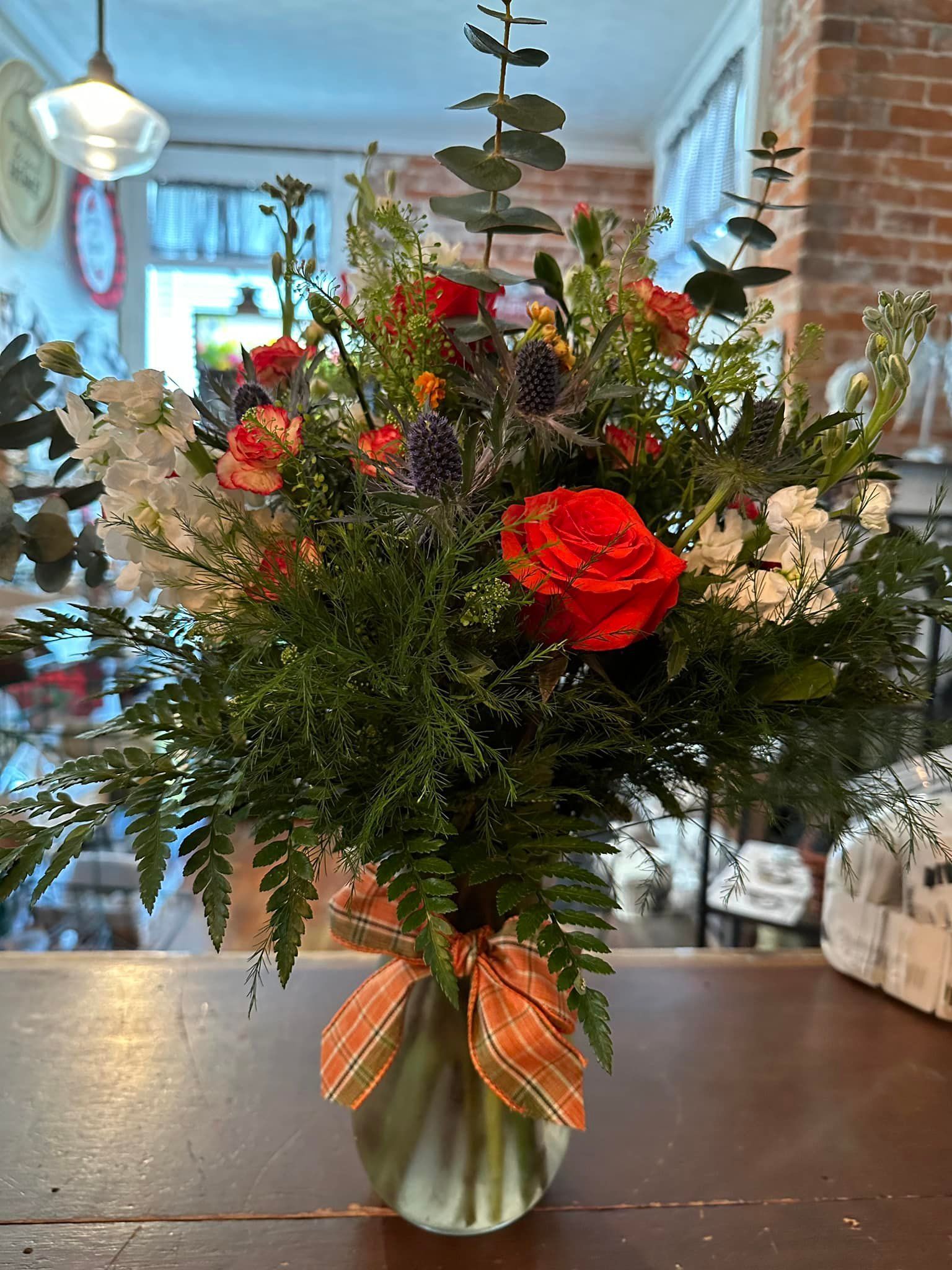 A vase filled with flowers is sitting on a wooden table.