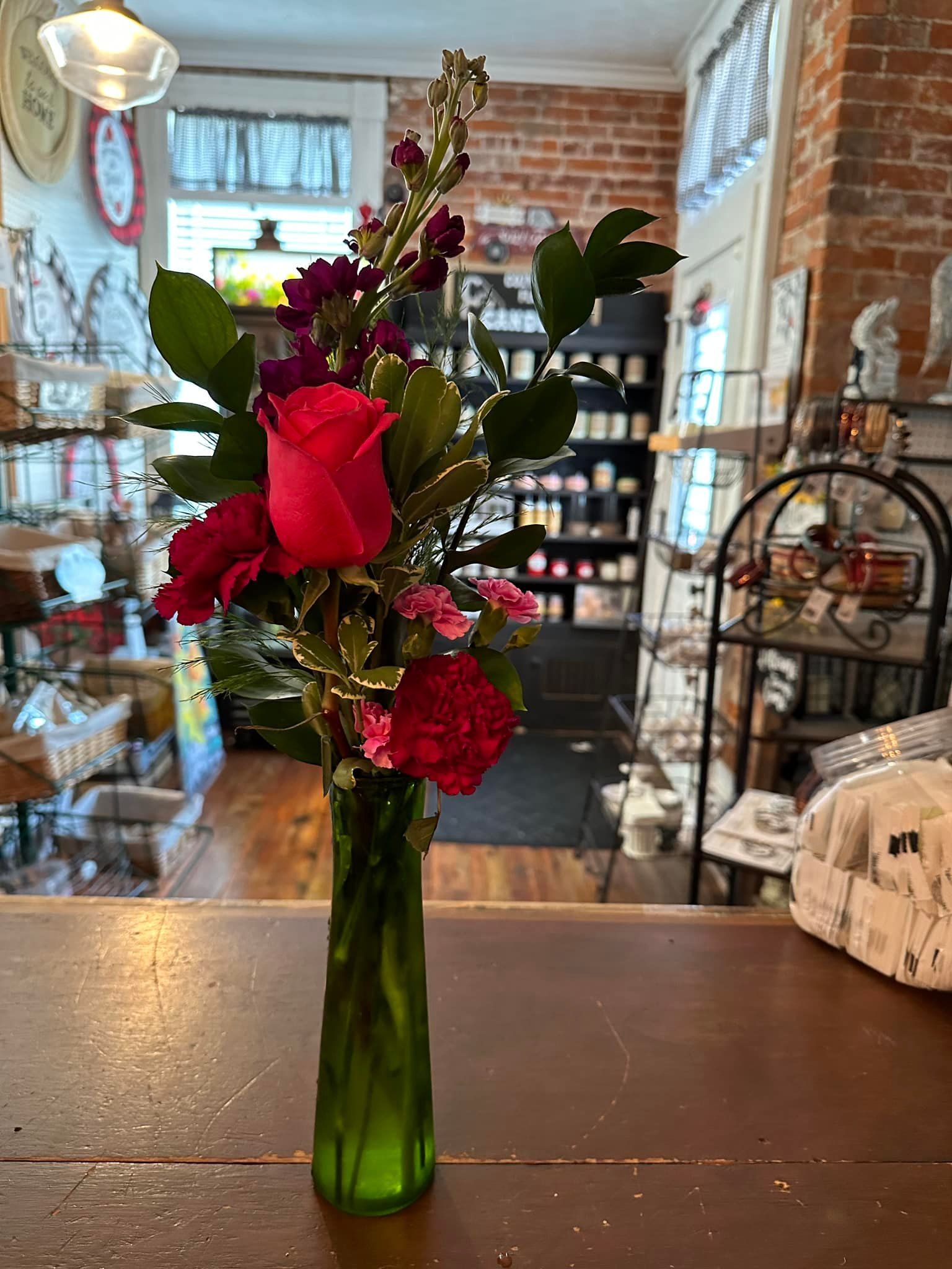A vase filled with flowers is sitting on a wooden table.