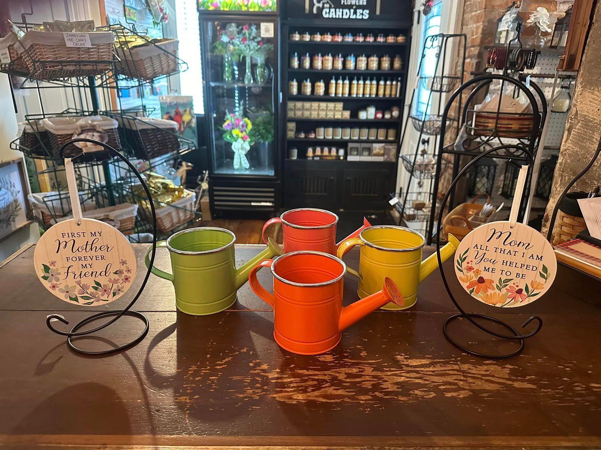 A group of watering cans sitting on top of a wooden table.
