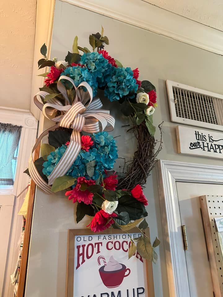 A wreath is hanging on a wall next to a sign that says hot cocoa.