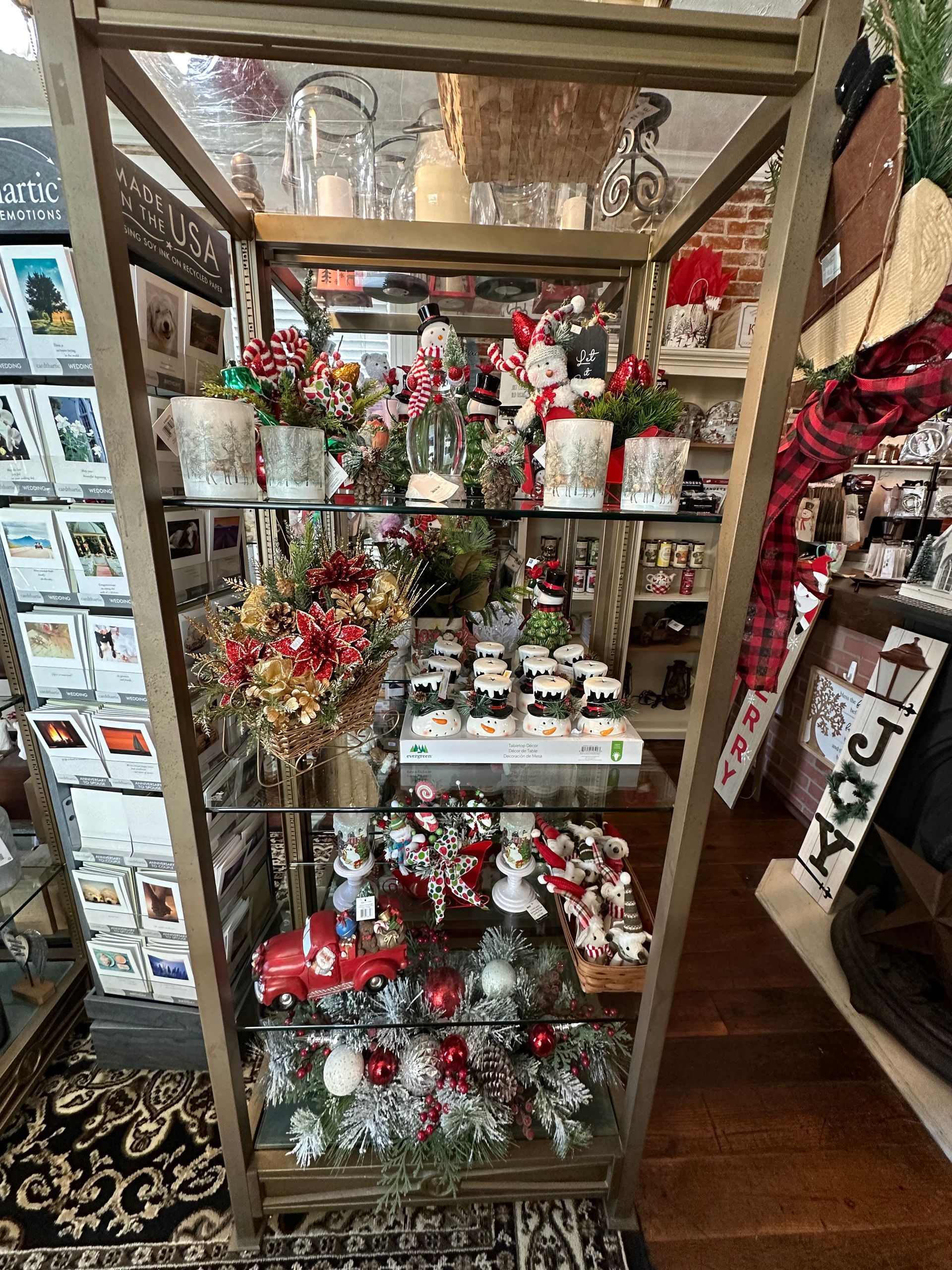 A glass display case filled with christmas decorations in a store.