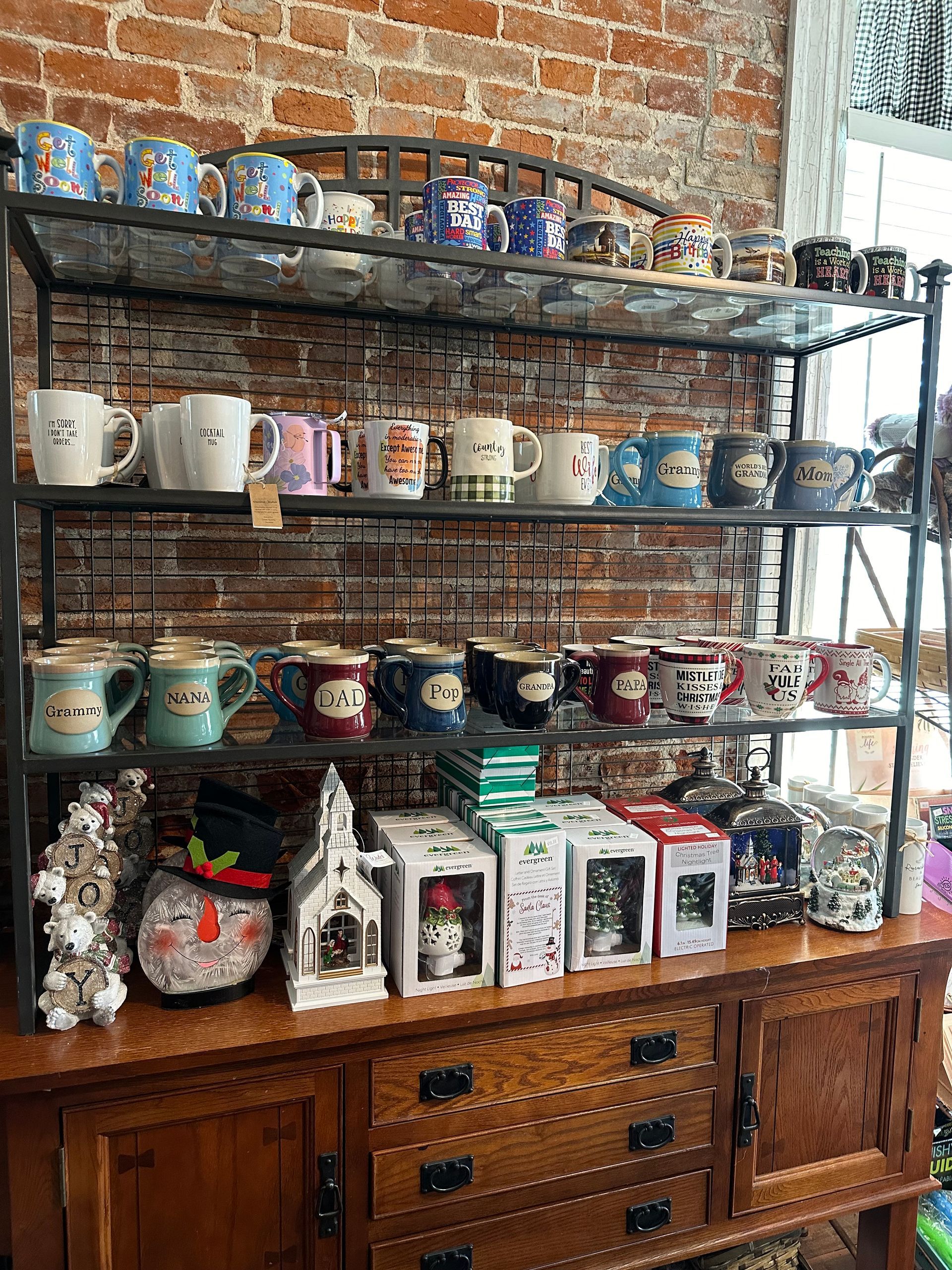 A shelf filled with lots of mugs and clocks in a store.