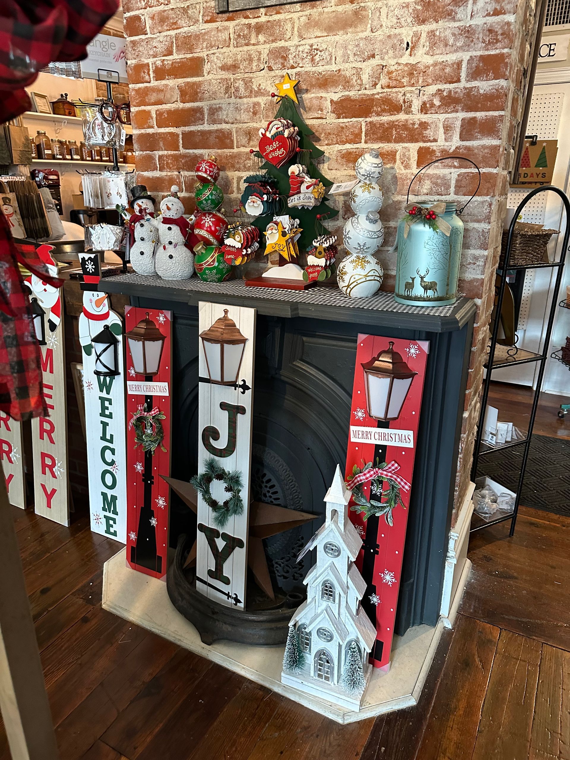 A fireplace with christmas decorations on it in a room with a brick wall.