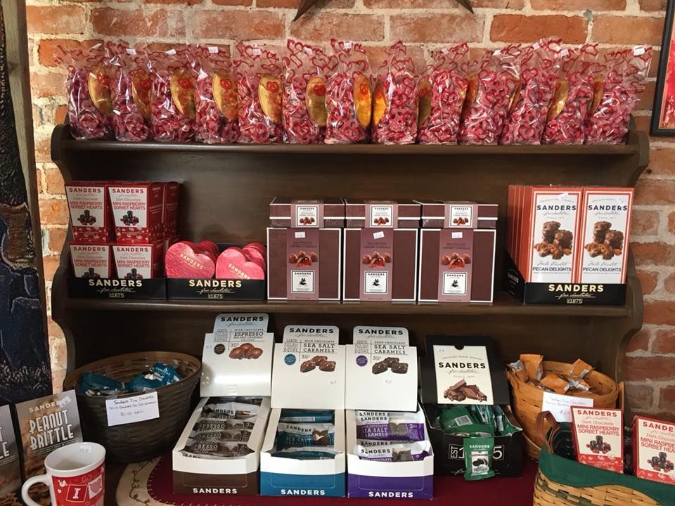 A shelf filled with lots of different types of chocolates.