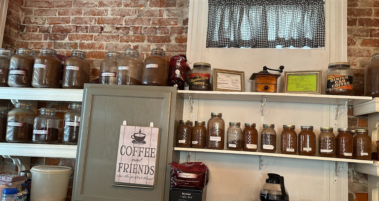 A shelf filled with jars of coffee and a sign that says `` coffee for sale ''.