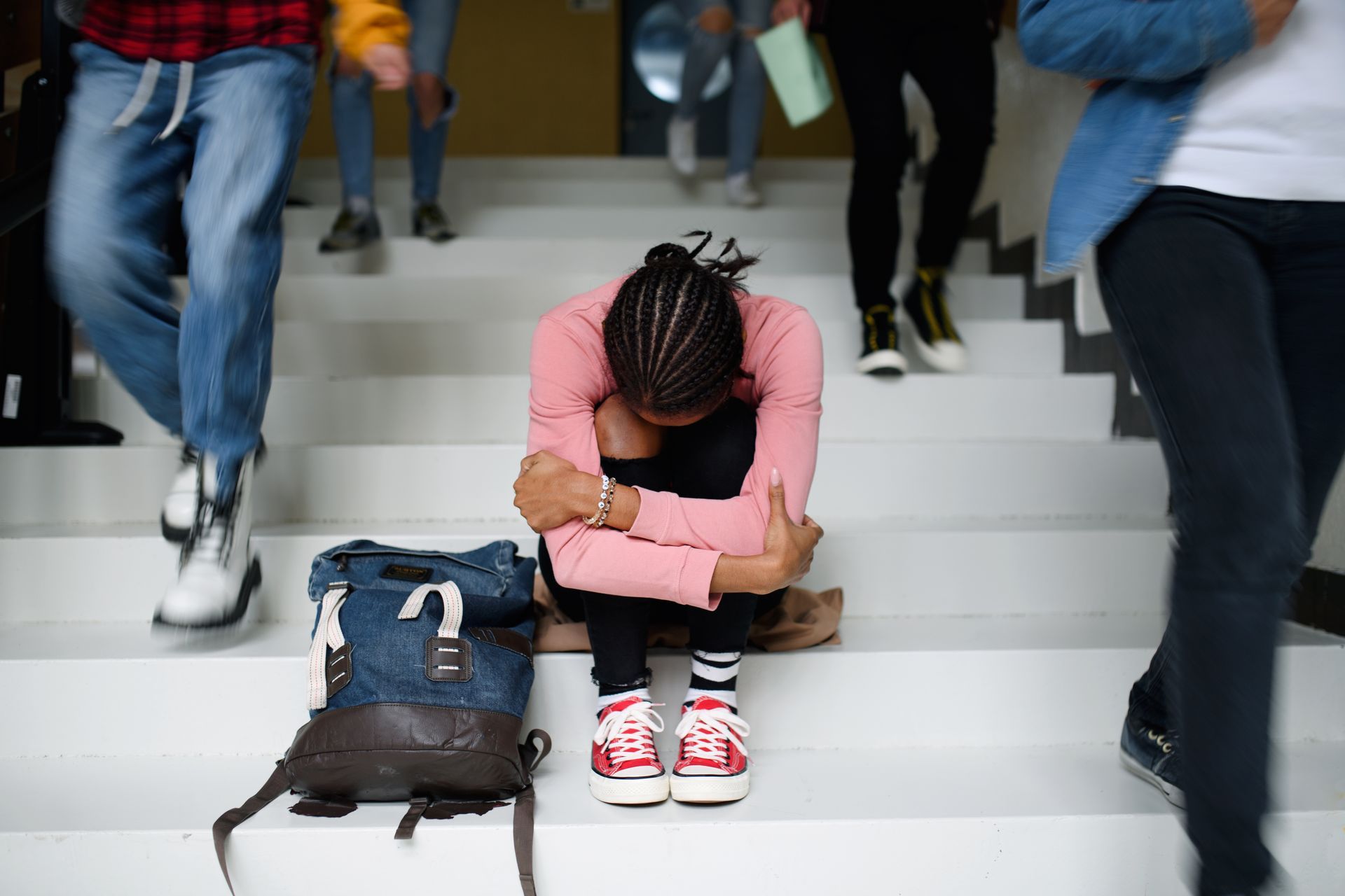 Girl sitting on the stairs with her head down