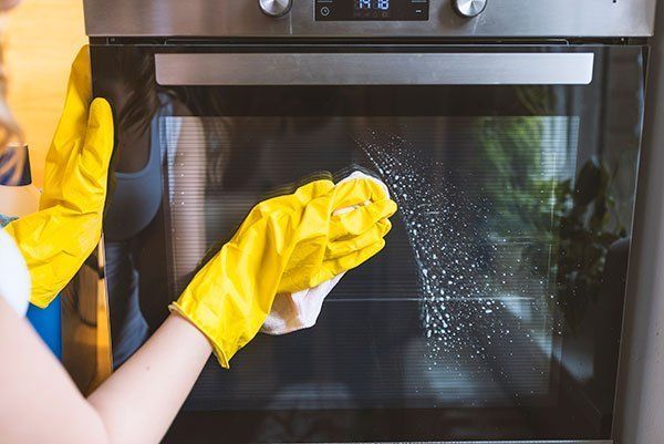 Removing Dust on Oven — DFW Airport, TX — Spotless Removing Dust on Oven — DFW Airport, TX — Spotless