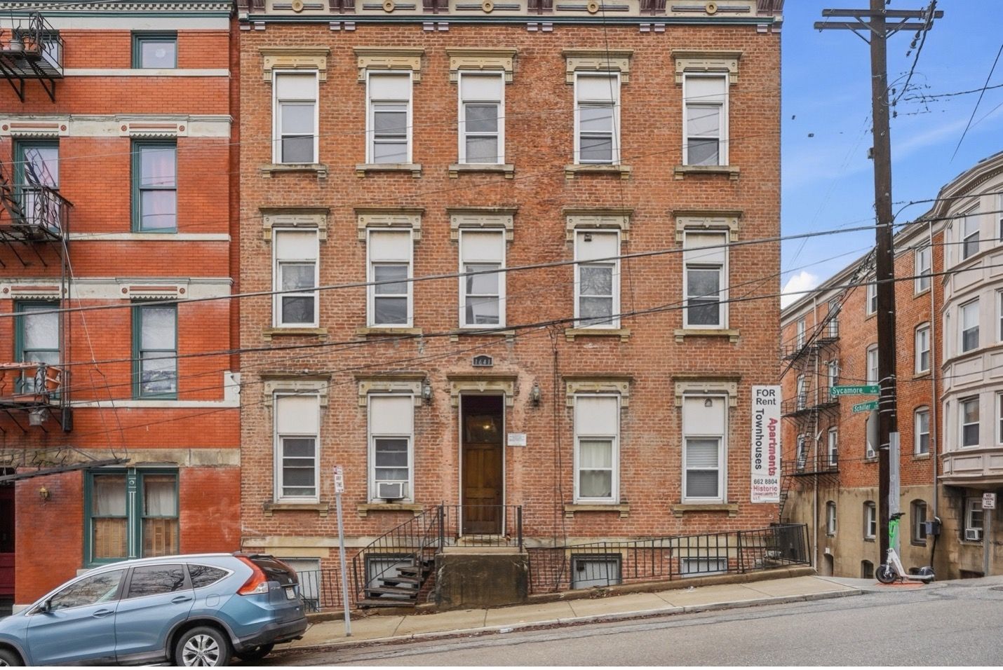 Tall blue glass skyscraper, upward perspective against a clear blue sky.