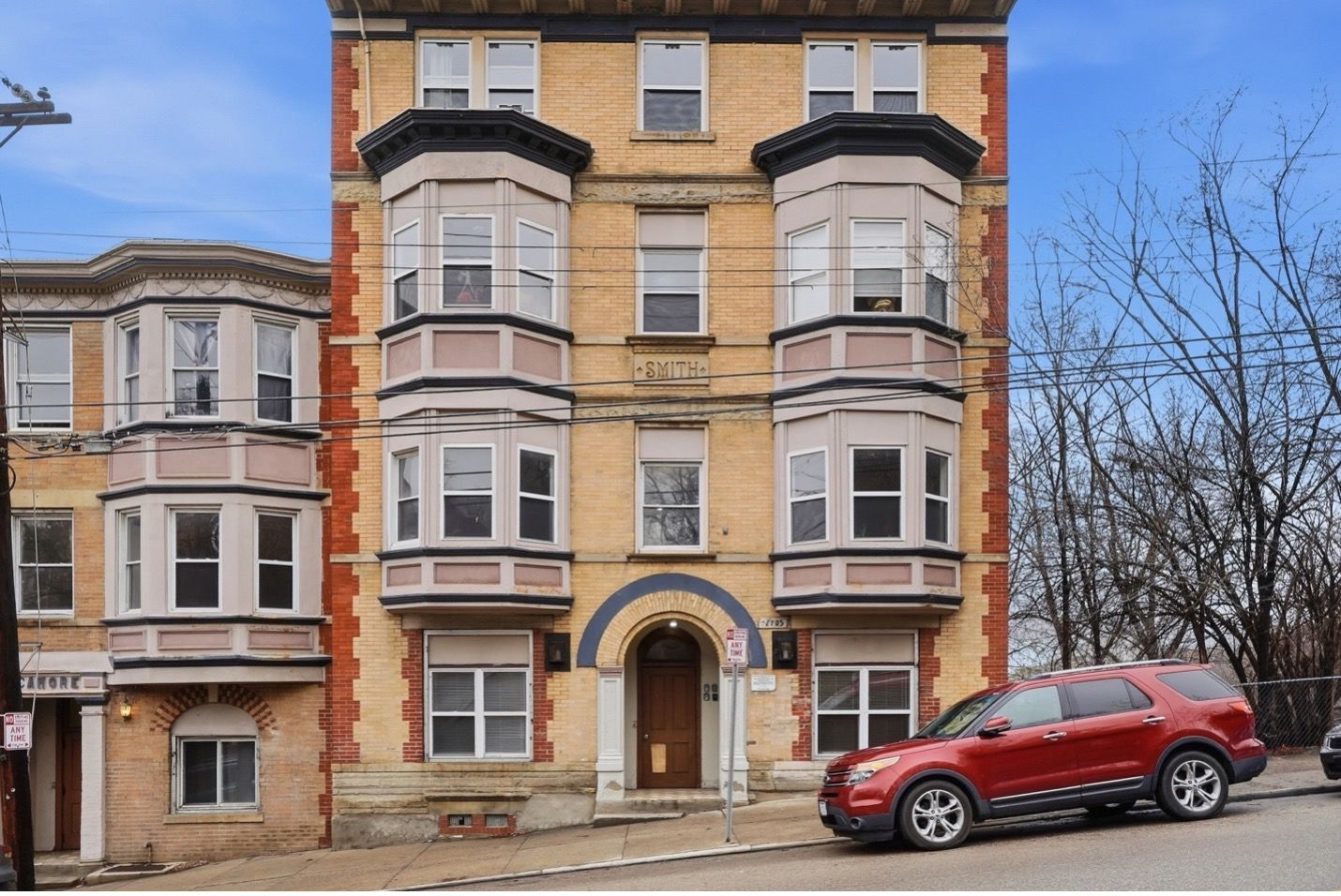 Gray building with square windows against a clear sky with a single cloud.