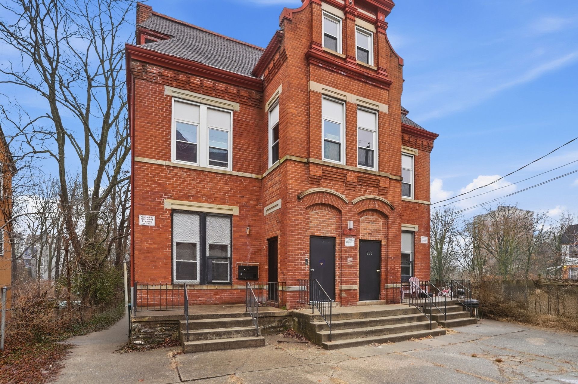 Tall white office building against a blue sky, topped with a radar dome.