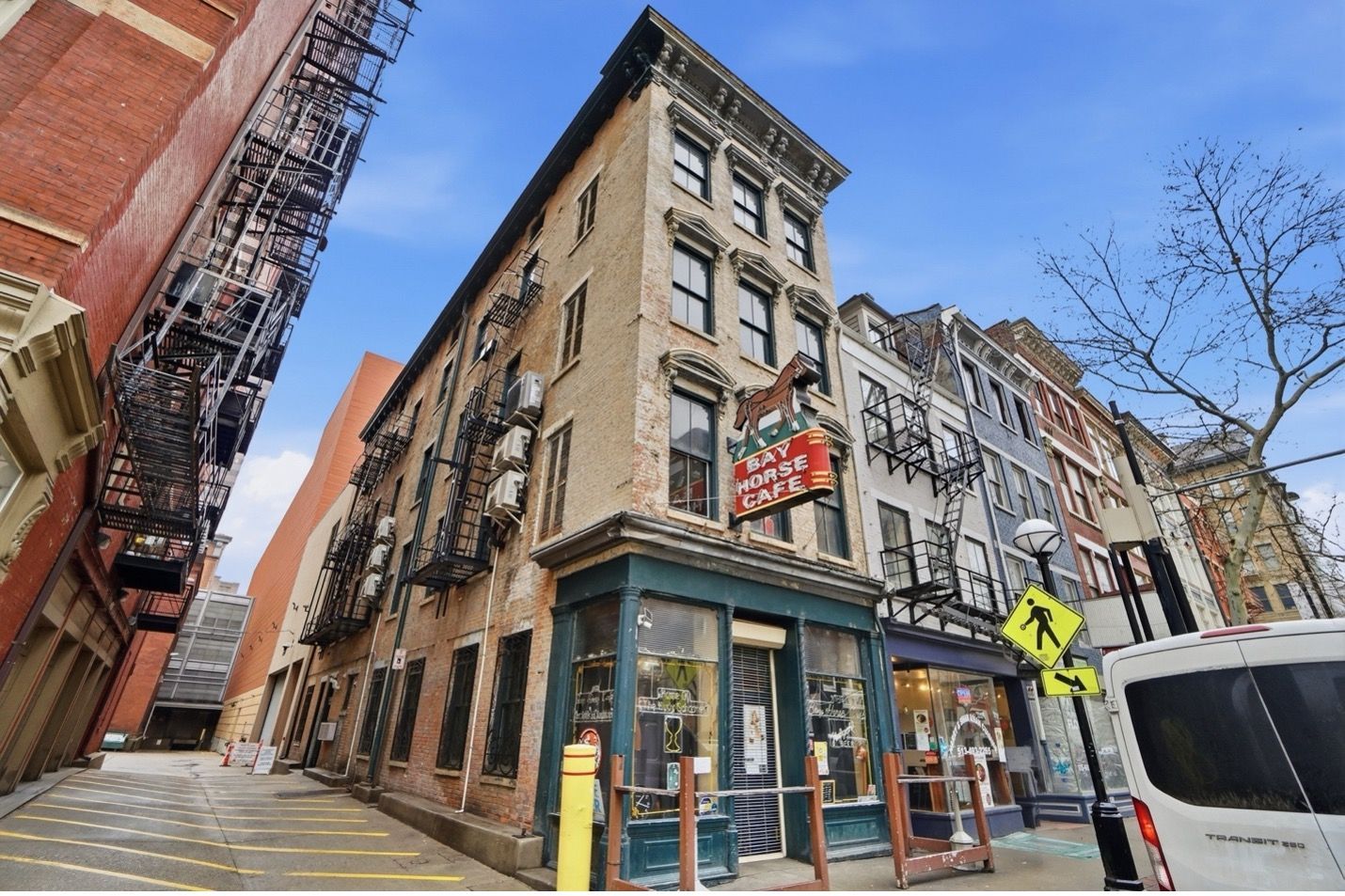 Stone steps leading up to tall apartment building against a blue sky.