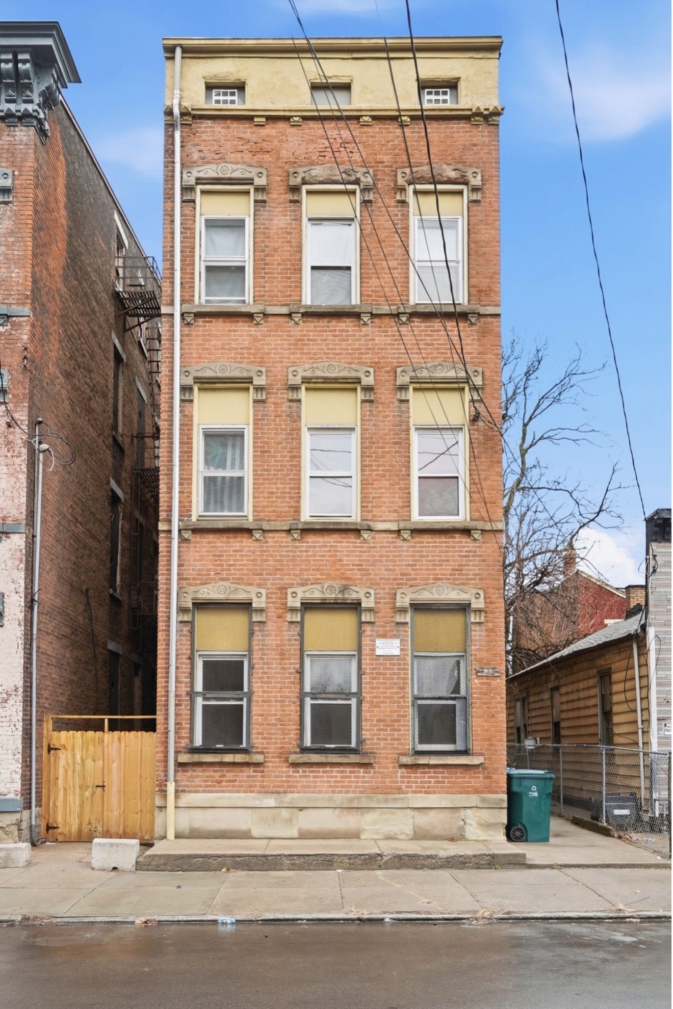 Tall teal and gray skyscraper with an ornate orange rooftop, clock, and antenna.