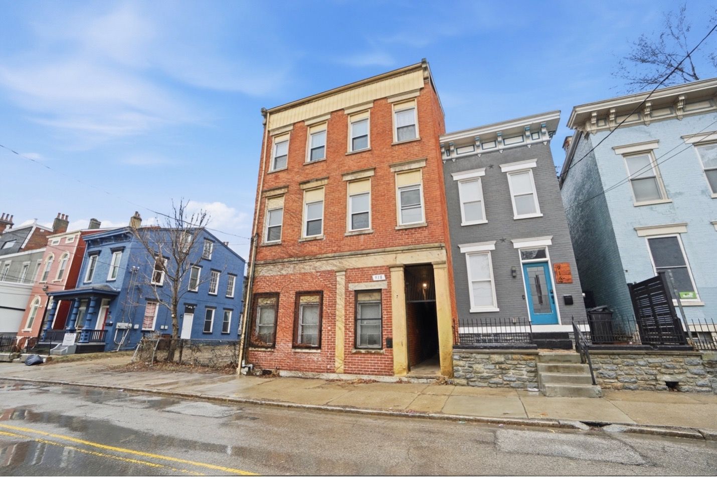 Close-up of a modern high-rise building with a textured, tan facade and dark rectangular windows.