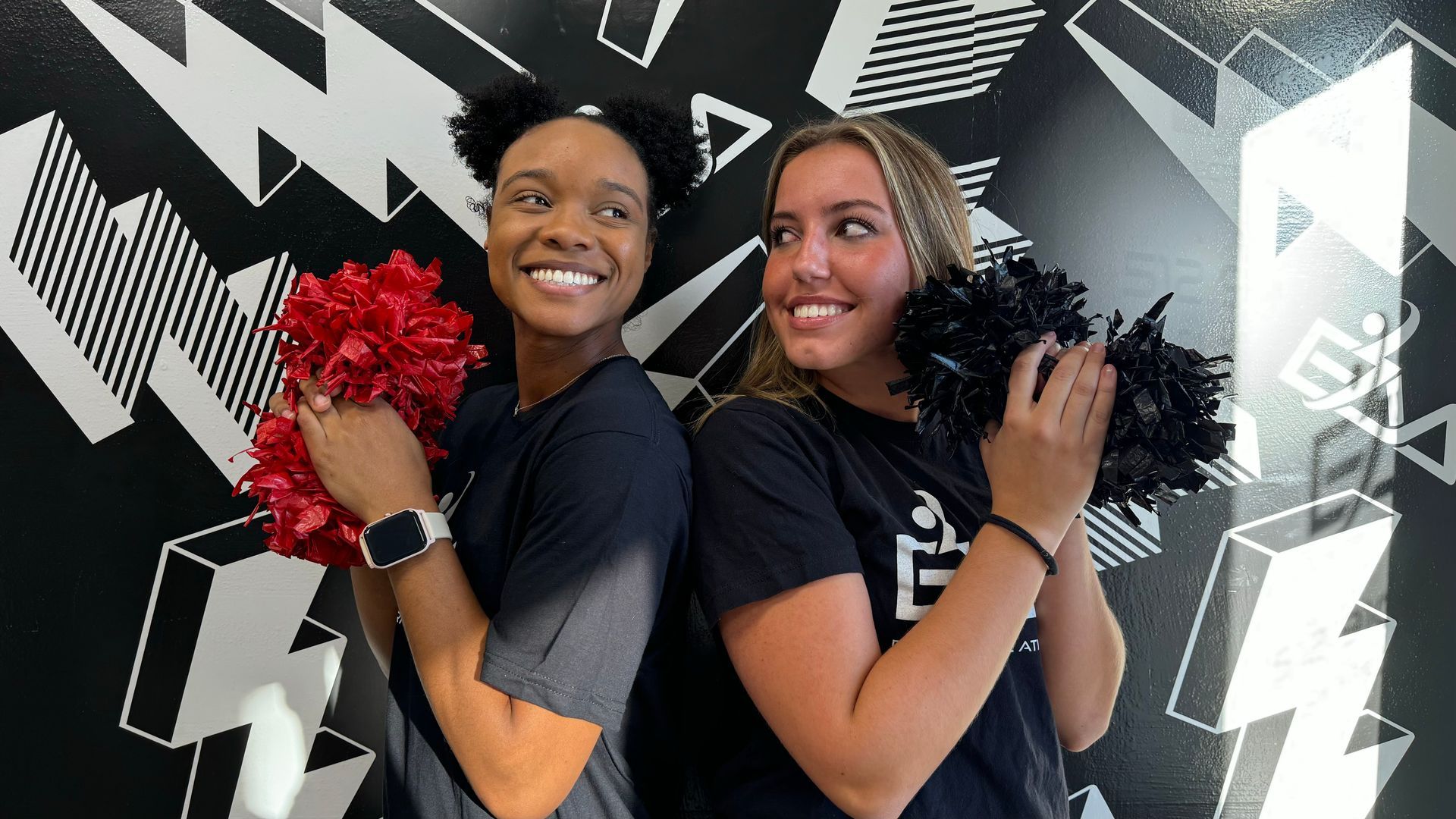 A group of people are standing next to each other with their arms in the air.