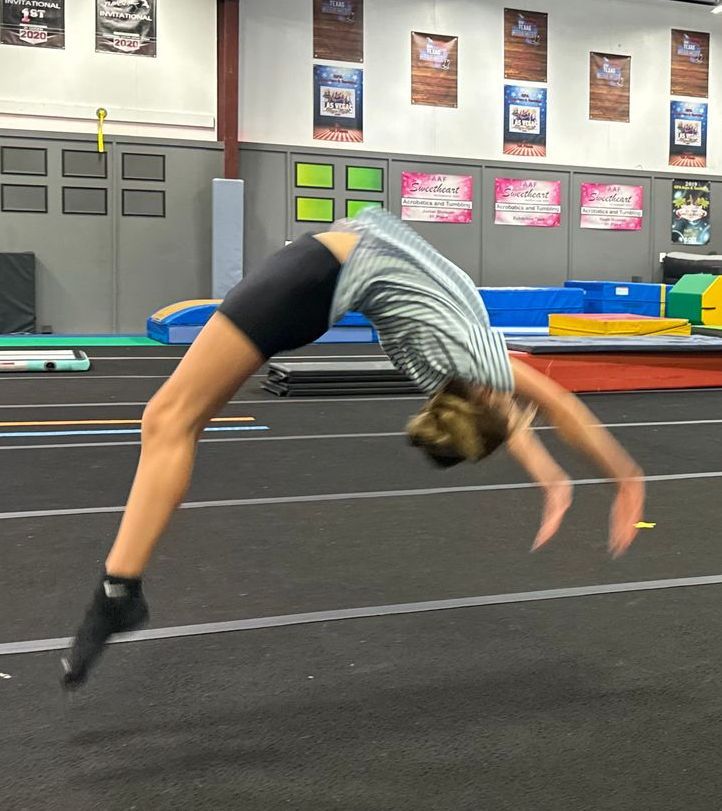 A person is doing a handstand in a gym