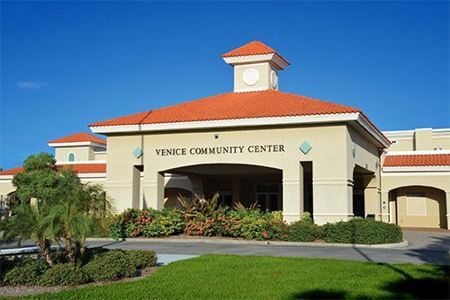 Yemen Community Center building exterior under a blue sky. Beige stucco with red tile roof.