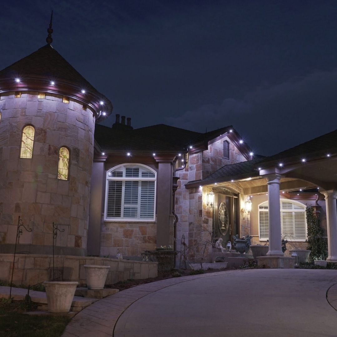 A large house is lit up at night with purple lights