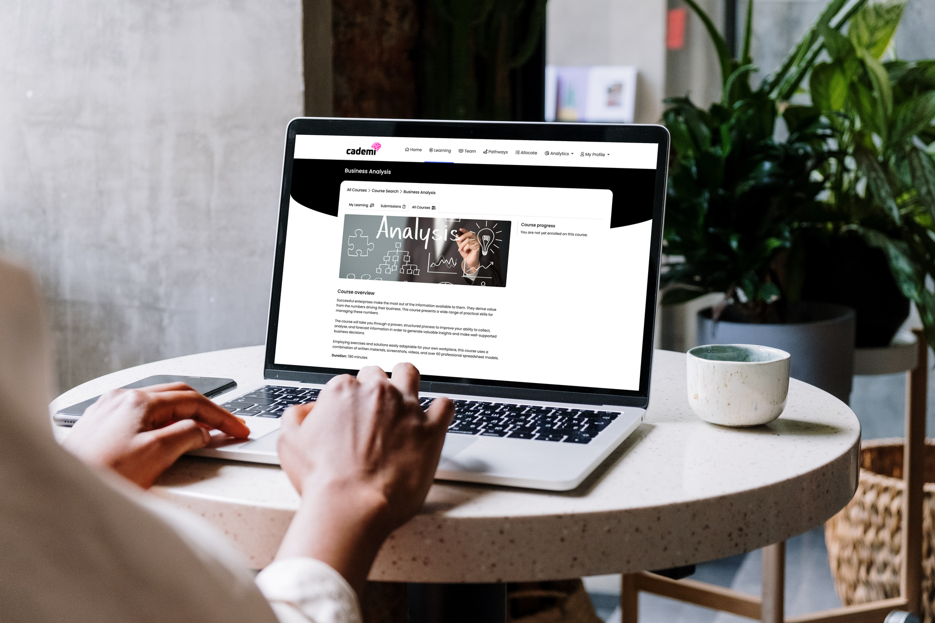 A group of people are sitting at a table with a laptop.