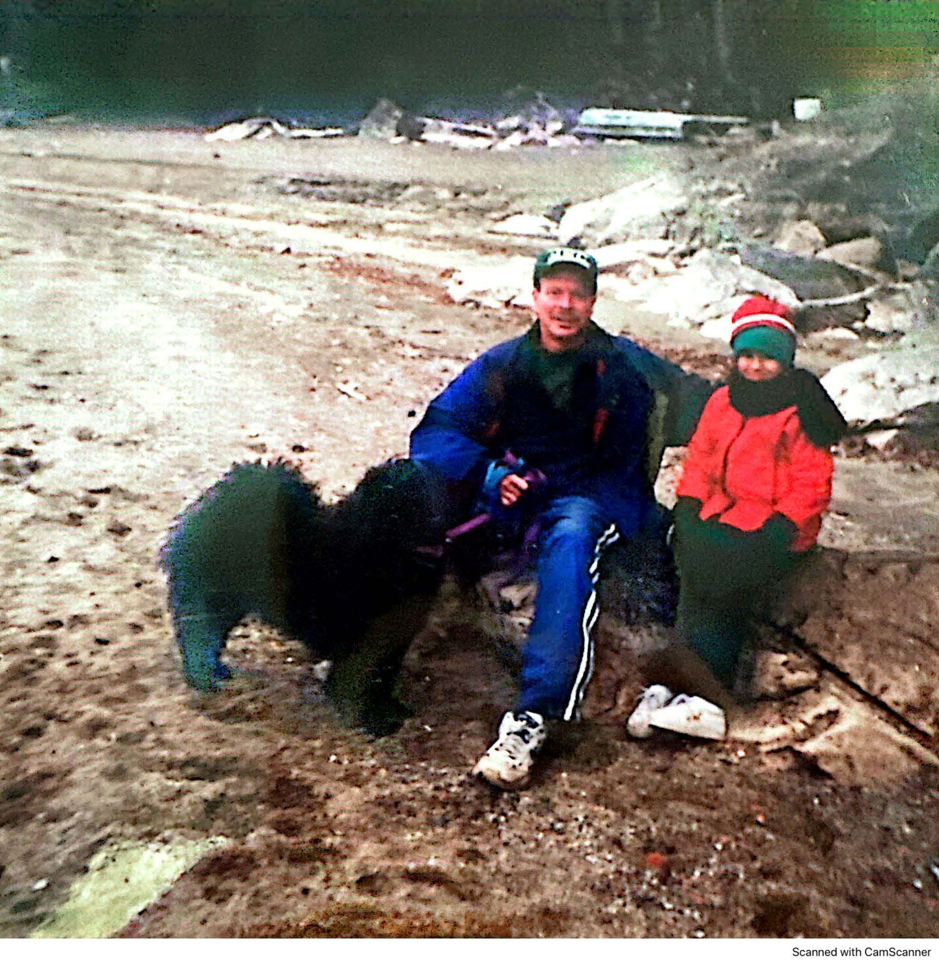 A man and a woman sitting on a rock with a dog-Burlington, VT-Elmwood-Meunier Funeral Home