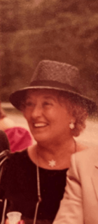 A woman wearing a hat is smiling for the camera.