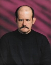 A bald man with a mustache is wearing a black shirt