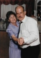 A man and a woman are dancing together in a room.