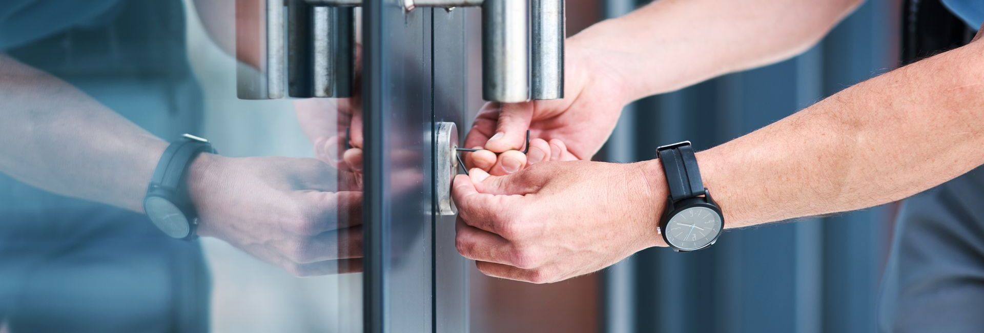 A man is opening a glass door with his hands.