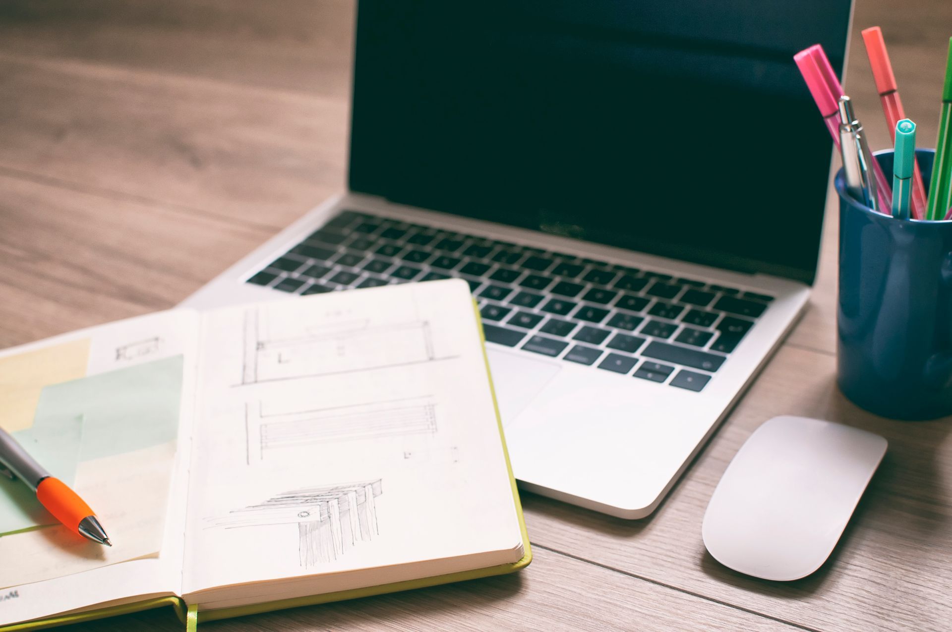 A keyboard , mouse , and pencil are on a wooden desk.