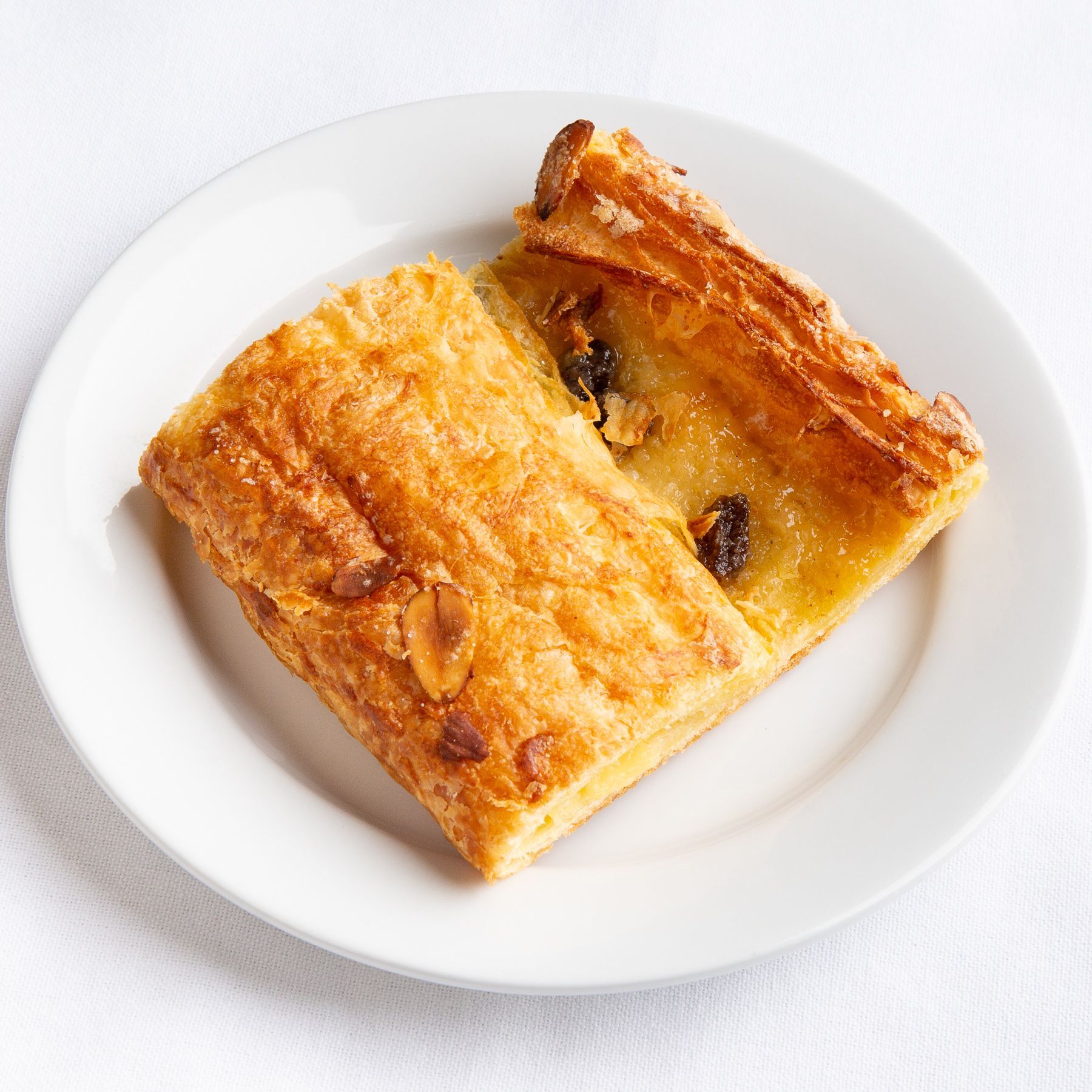 Two rectangular pastries with nuts and raisins on a white plate.