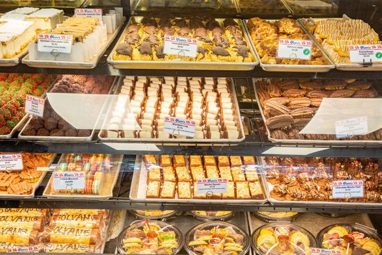 Bakery display case filled with various baked goods: cakes, cookies, and bars.