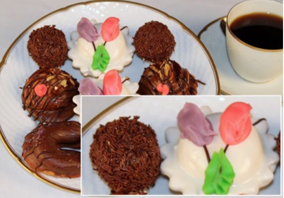 Plate of assorted pastries with coffee cup. Chocolate and flower-shaped confections.
