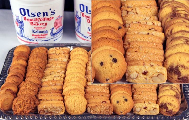 Assorted cookies on a tray, with tubs of Olsen's Danish Village Bakery in the background.