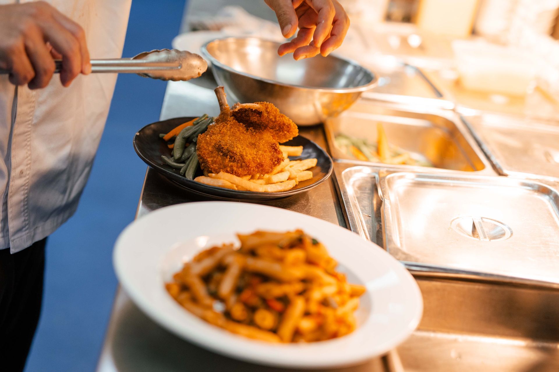 A person is preparing a plate of food in a kitchen