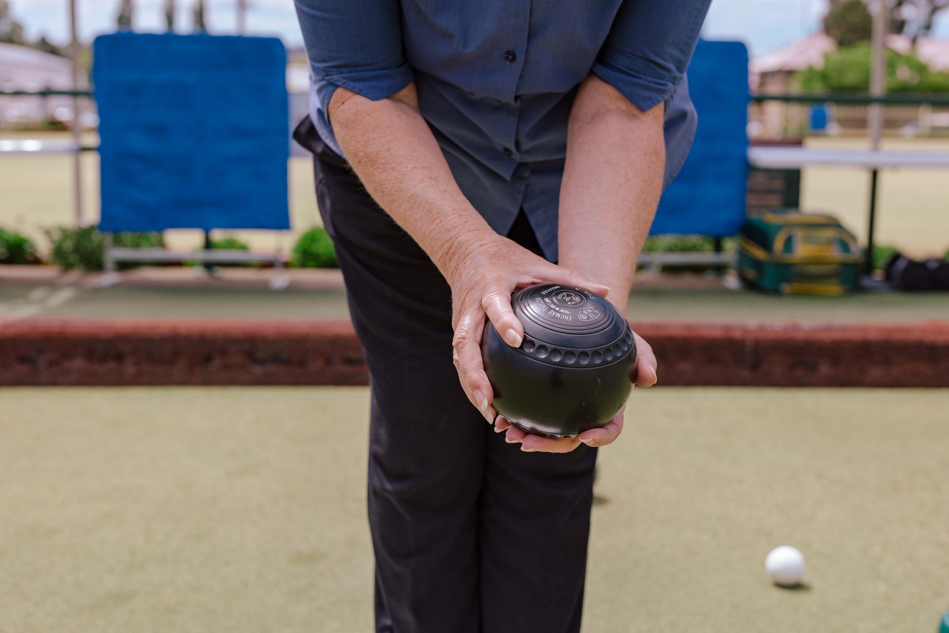A person is holding a bowling ball in their hands
