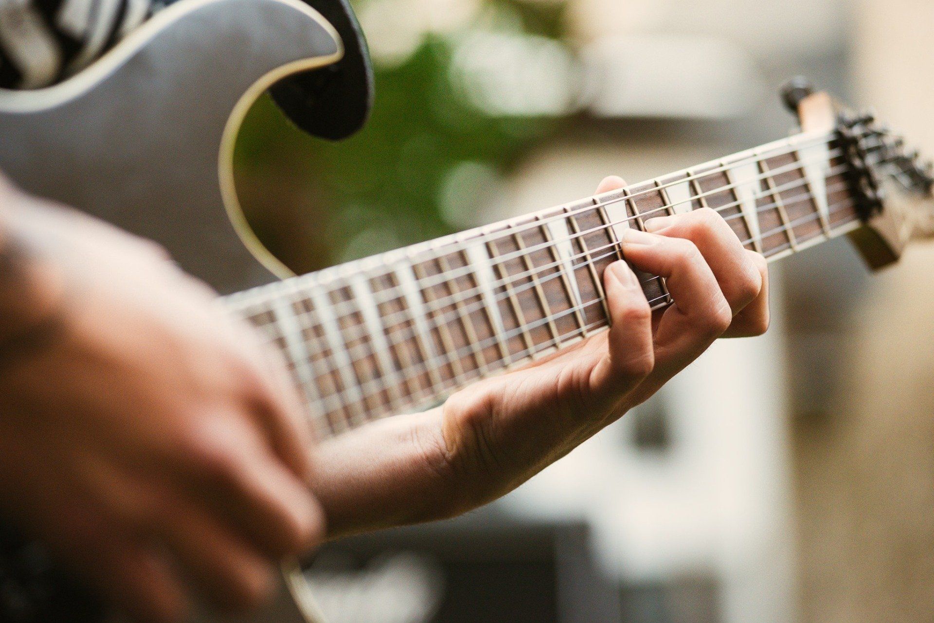A close up of a person playing an electric guitar
